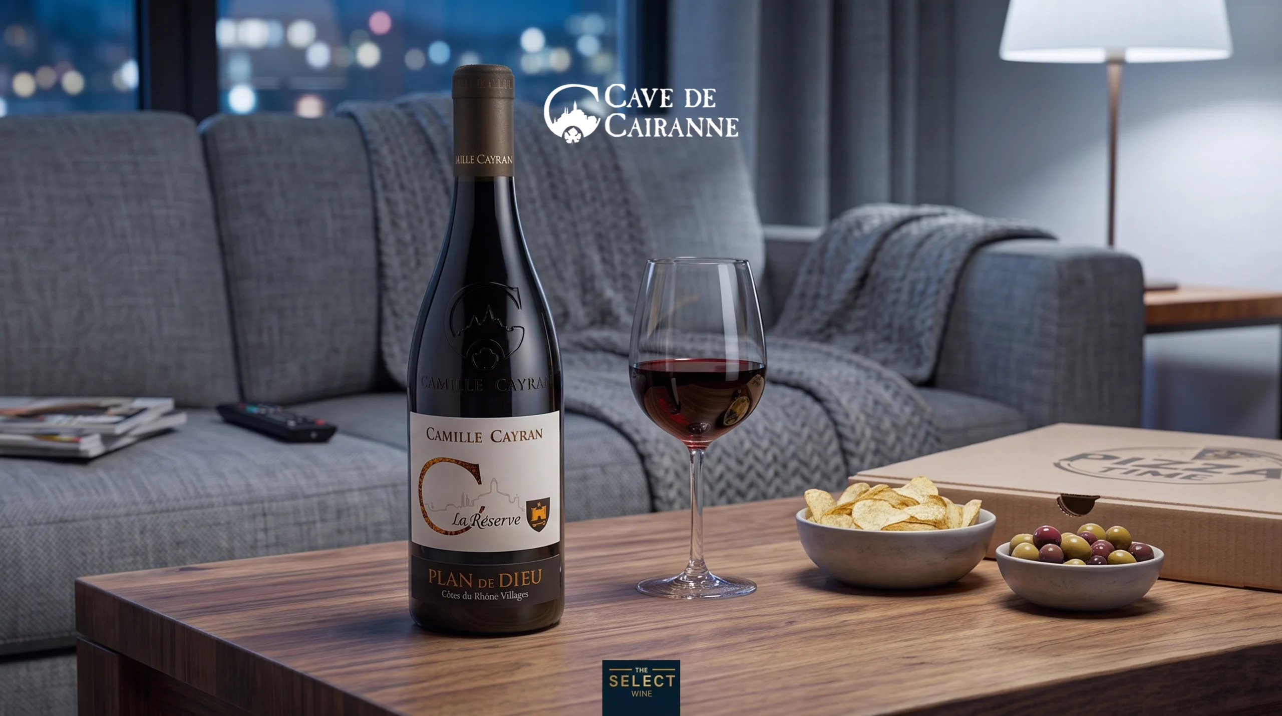 A bottle of Cave de Cairanne red wine and takeout food on a coffee table in a cozy living room.